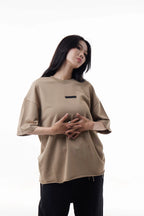 Woman wearing a khaki Raw Edge Tee