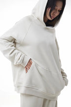 Woman wearing a white Essential Hoodie