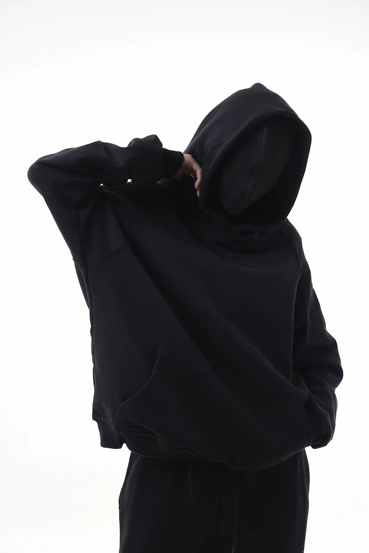 Person wearing a black Essential Hoodie