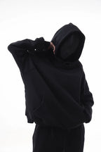 Person wearing a black Essential Hoodie